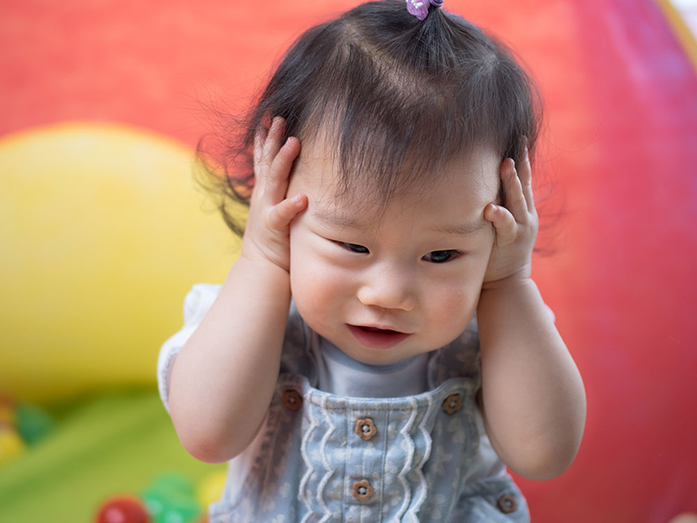 Baby crying with store legs out straight