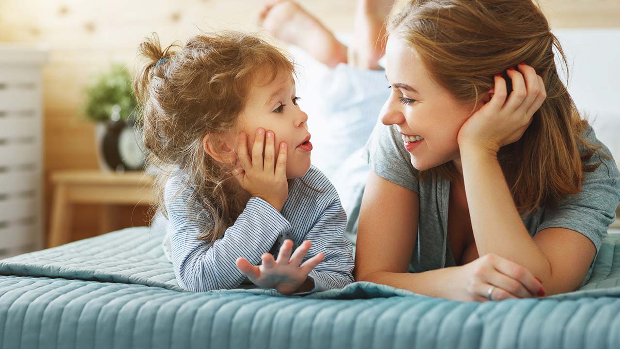 Smiling mother playing with her son pretending him