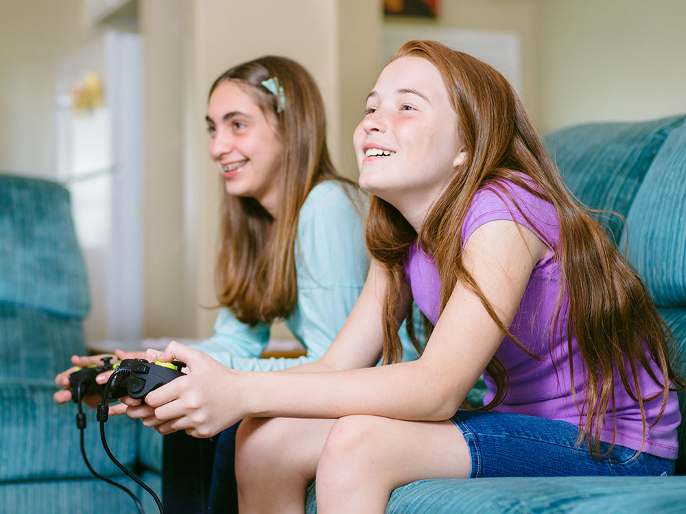 Happy young man playing and winning online game on computer. Back view of  gamer with video console gamepad controller. Competitive gaming, electronic  sports, technology, gaming, entertainment concept. Stock Photo